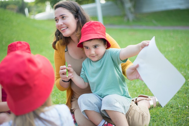 A kid playing in the park with a woman